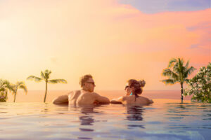 Couple enjoying sunset views from an infinity pool in Bali – perfect moment during a Bali honeymoon package from Nepal